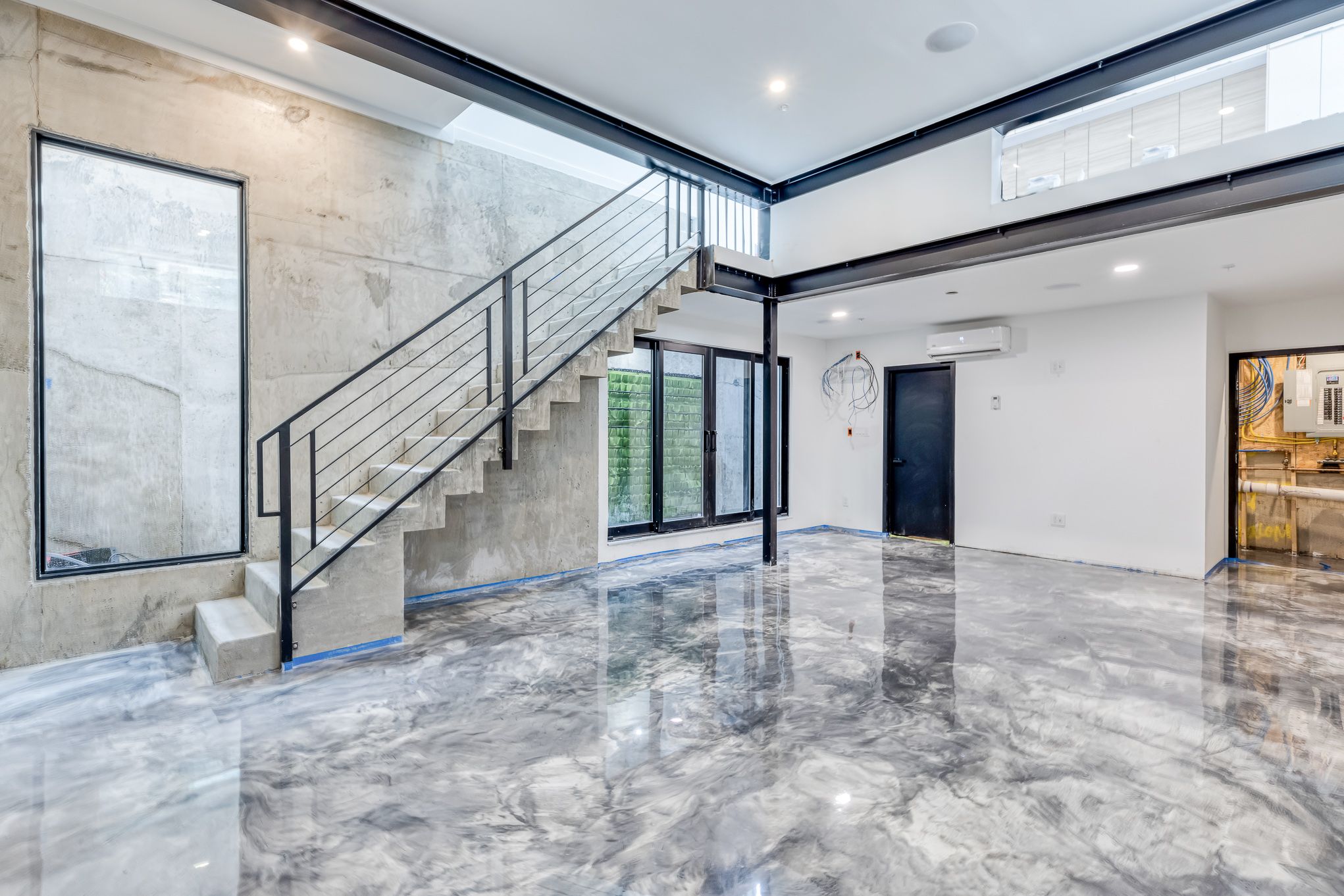 Polished concrete floors in the double-height living space in Kensington