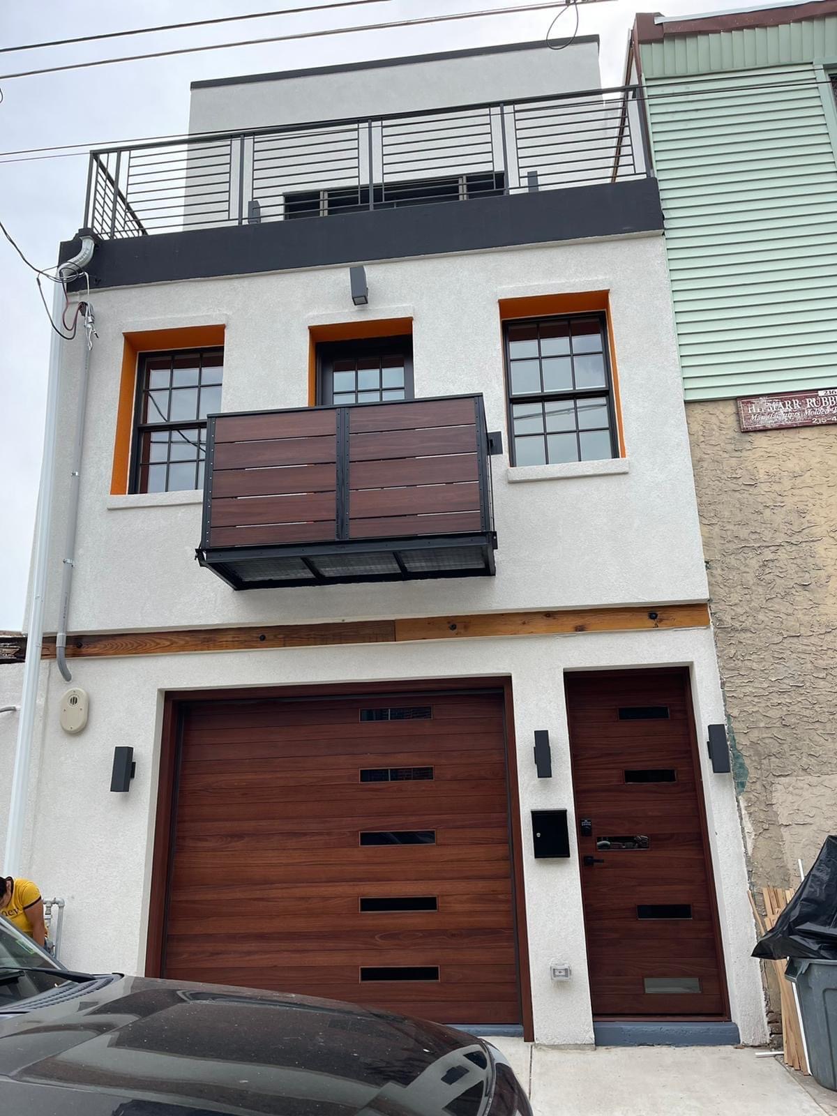 Front facade with custom garage door and balcony detail
