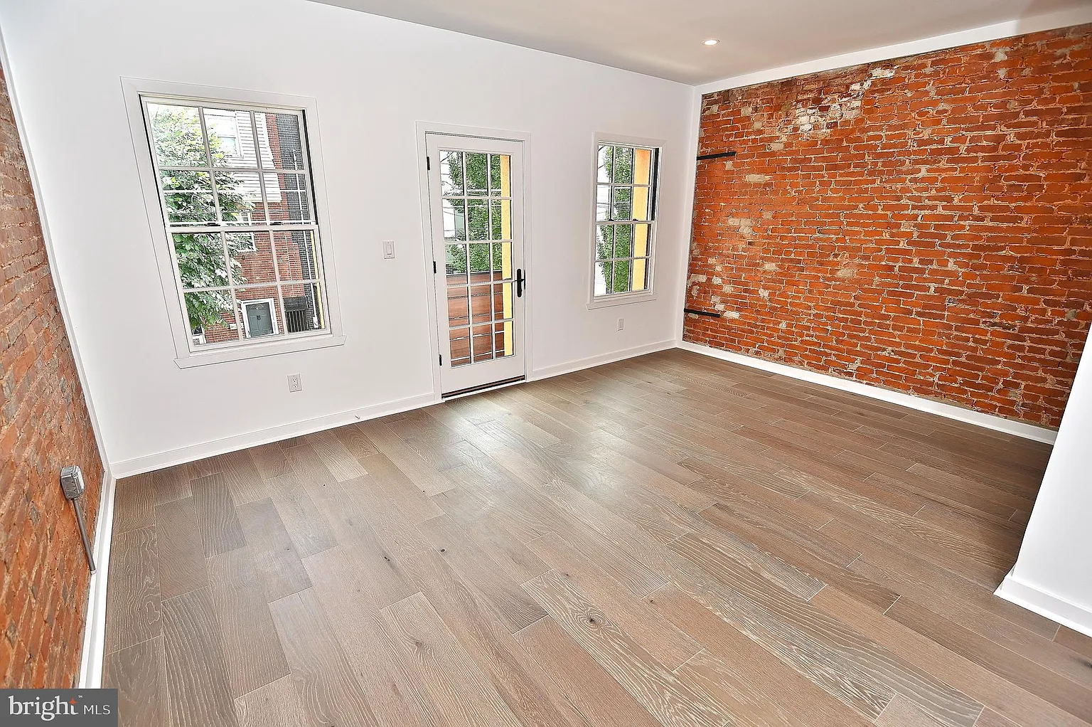 Living space with exposed brick and new wood flooring