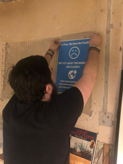 Murphy Rhodes hangs a poster up
