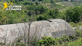 Veduta aerea di un complesso industriale con tetti in cemento-amianto deteriorato oggetto di sequestro da parte della Guardia di Finanza