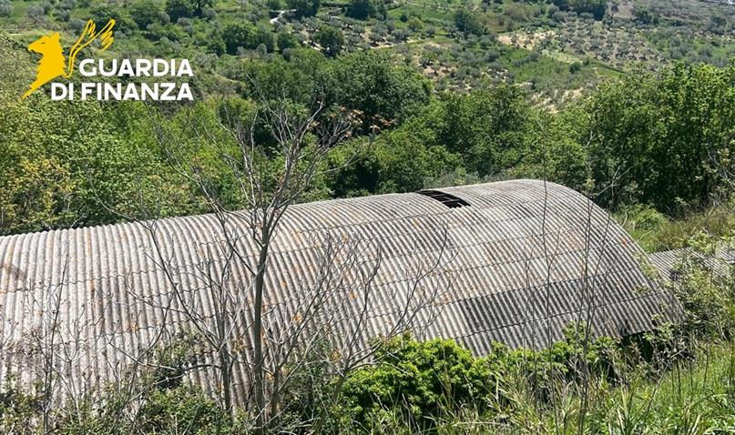 Veduta aerea di un complesso industriale con tetti in cemento-amianto deteriorato oggetto di sequestro da parte della Guardia di Finanza