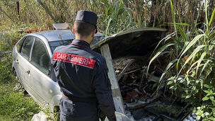Carabinieri Forestali ispezionano un'area recintata a fondo naturale piena di rifiuti ingombranti, elettrodomestici e carcasse d'auto