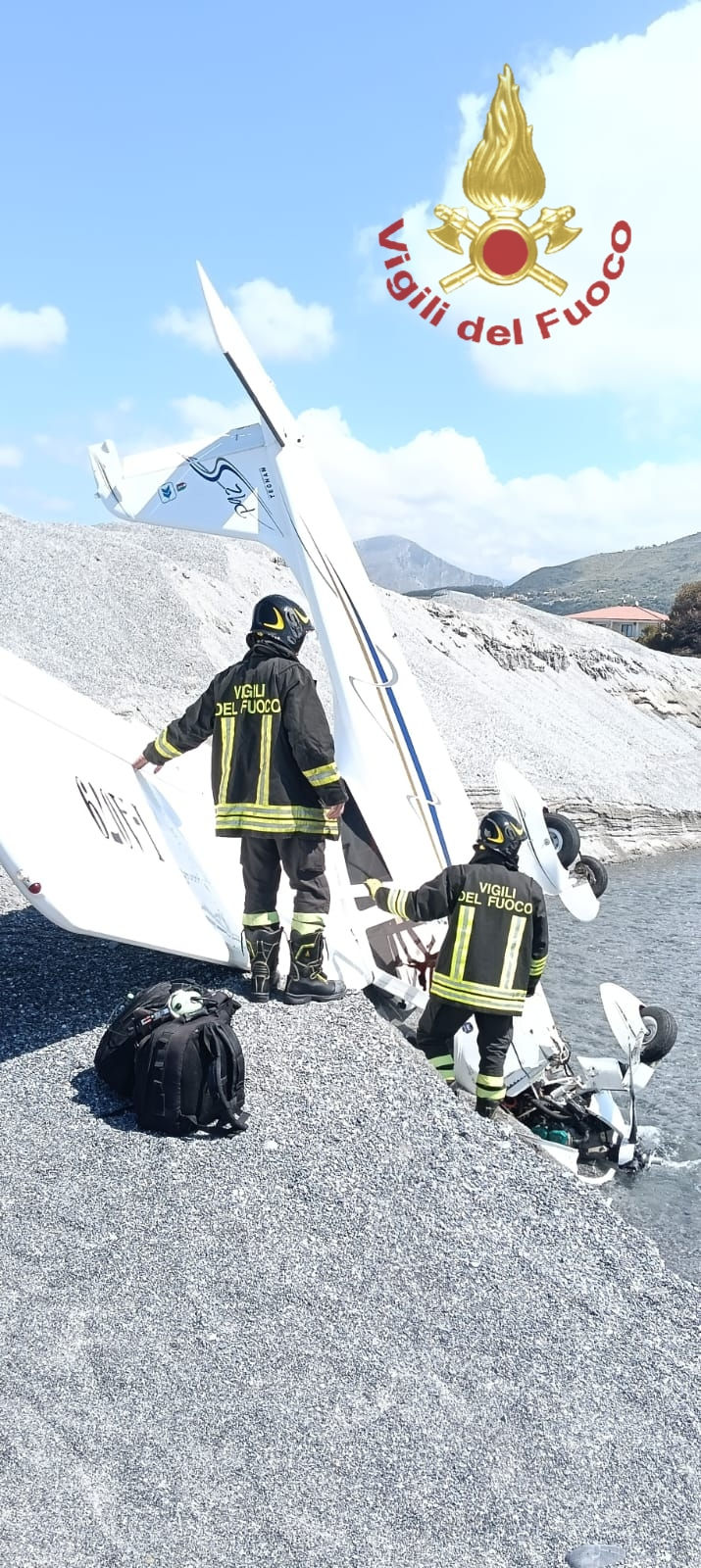 Un aereo ultraleggero modello P92 Tecnam fermo sulla sabbia della spiaggia di Grisolia Lido, circondato dai mezzi di soccorso dei Vigili del Fuoco