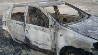 Resti della Fiat Uno rossa distrutta da un incendio a Scalea