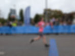 Runner crossing finish line of first half marathon, illustrating lessons about patience and progress in dog training