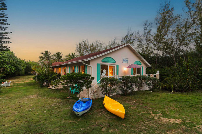 A house with two kayaks positioned in front, showcasing a serene outdoor setting.