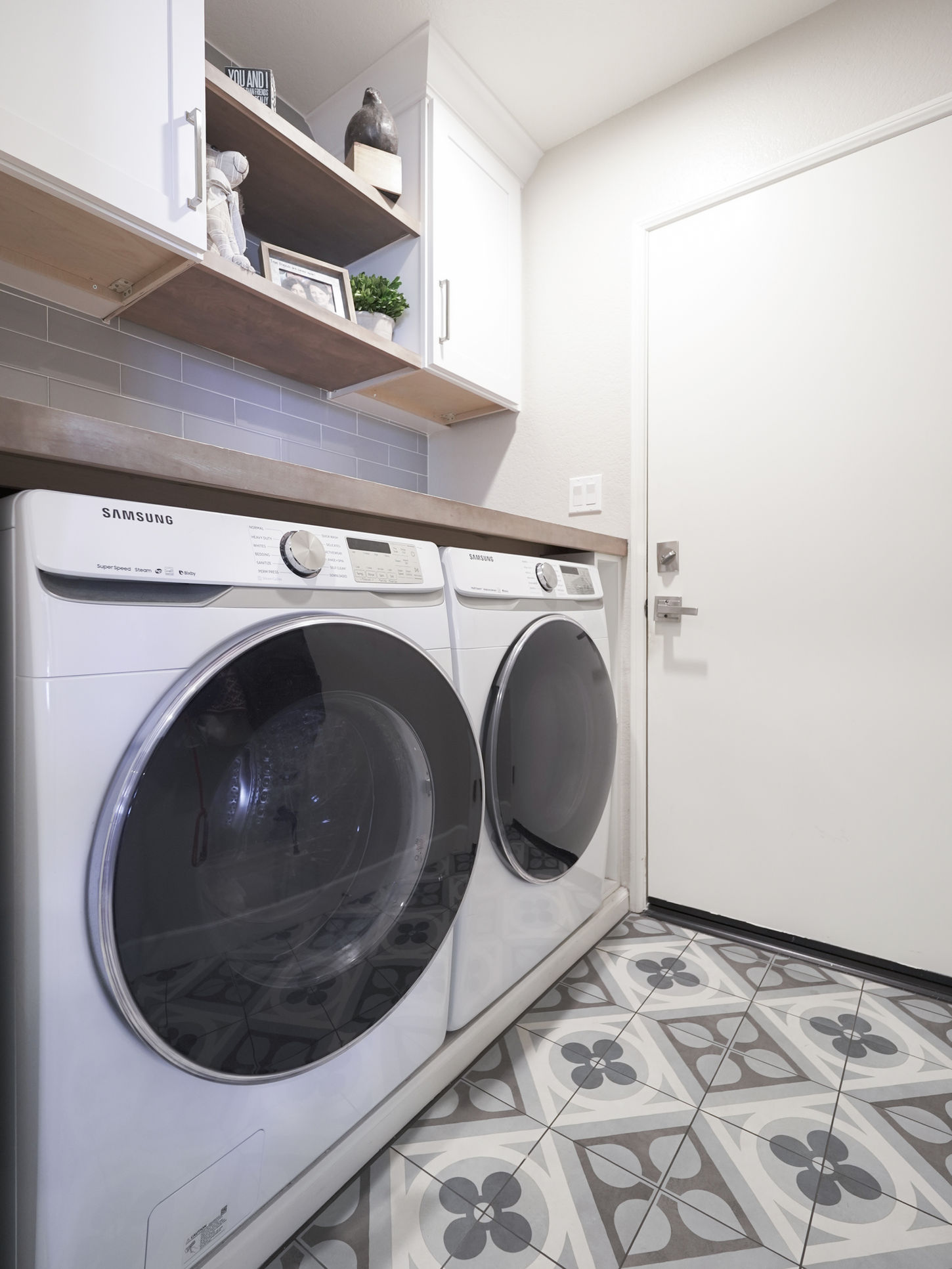 luxury laundry room with wood shelves and contemporary tile