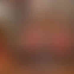 Boutique display of cocktail glasses, drinkware, books, and bar accessories arranged on wooden shelves with flowers.