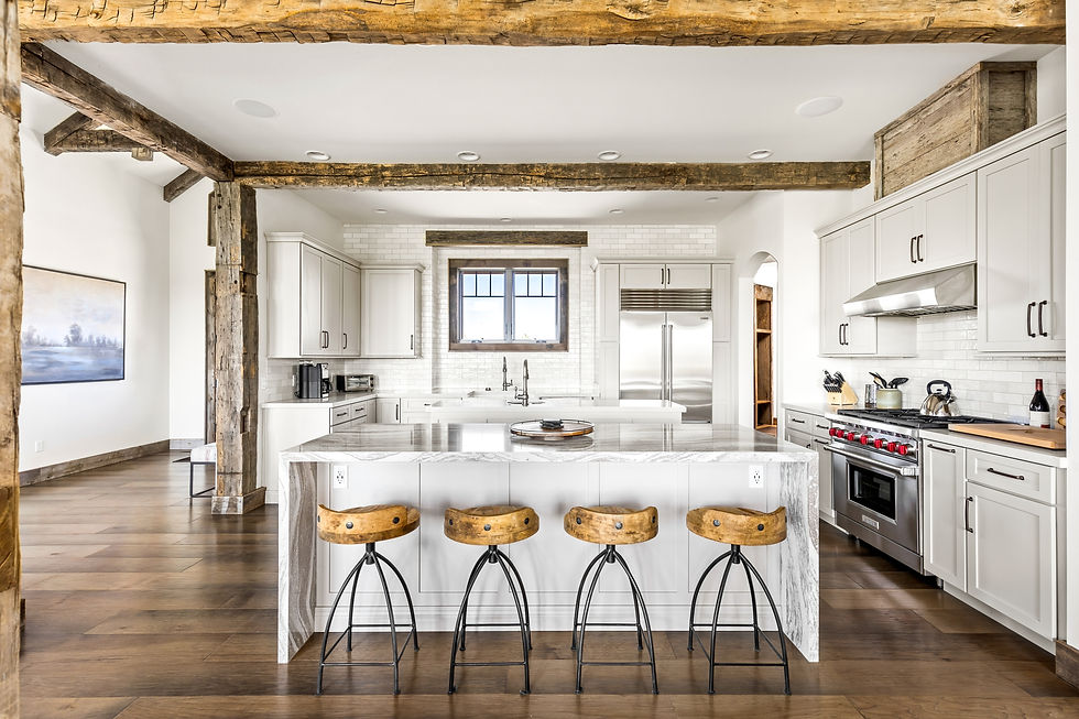 Rustic kitchen with wooden beams, white cabinets, marble island, four wooden barstools, and stainless steel appliances. Cozy and inviting.