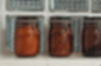 Brown glass jars containing, tea, coffee, sugar and biscuits on a window sill