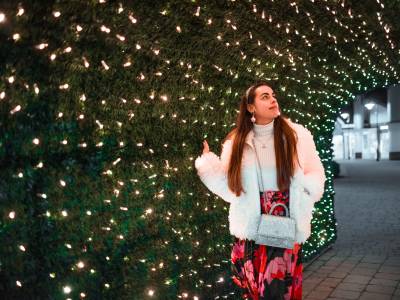 Woman walking under Christmas lights