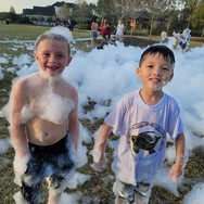 two children smiling covered in foam
