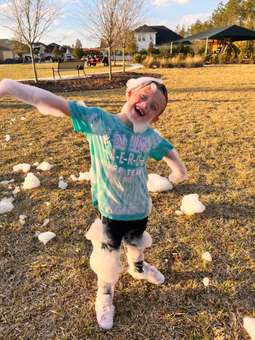 child covered in foam and a big smile