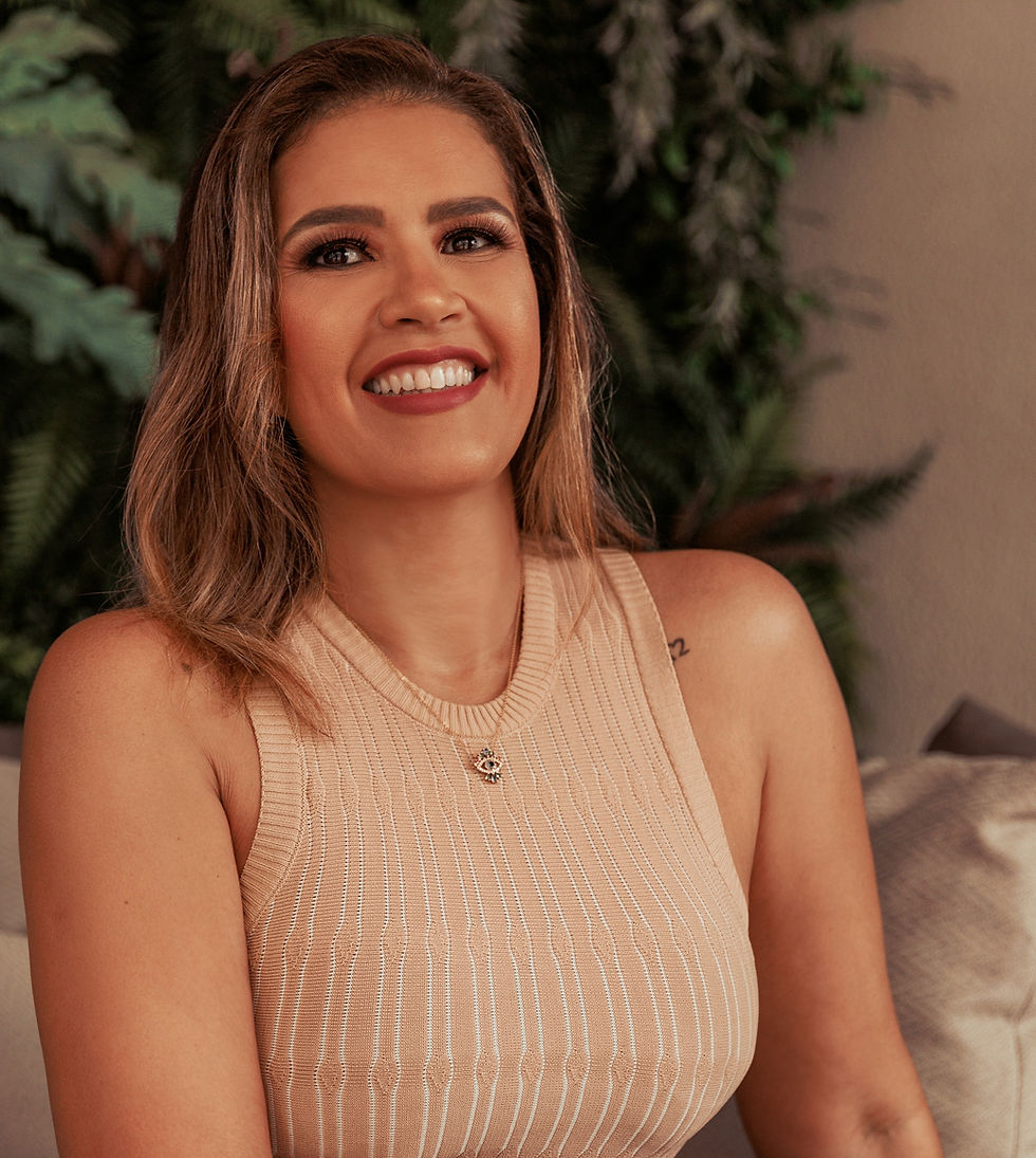 Imagem da arquiteta Aline sorridente com blusa bege em ambiente decorado.