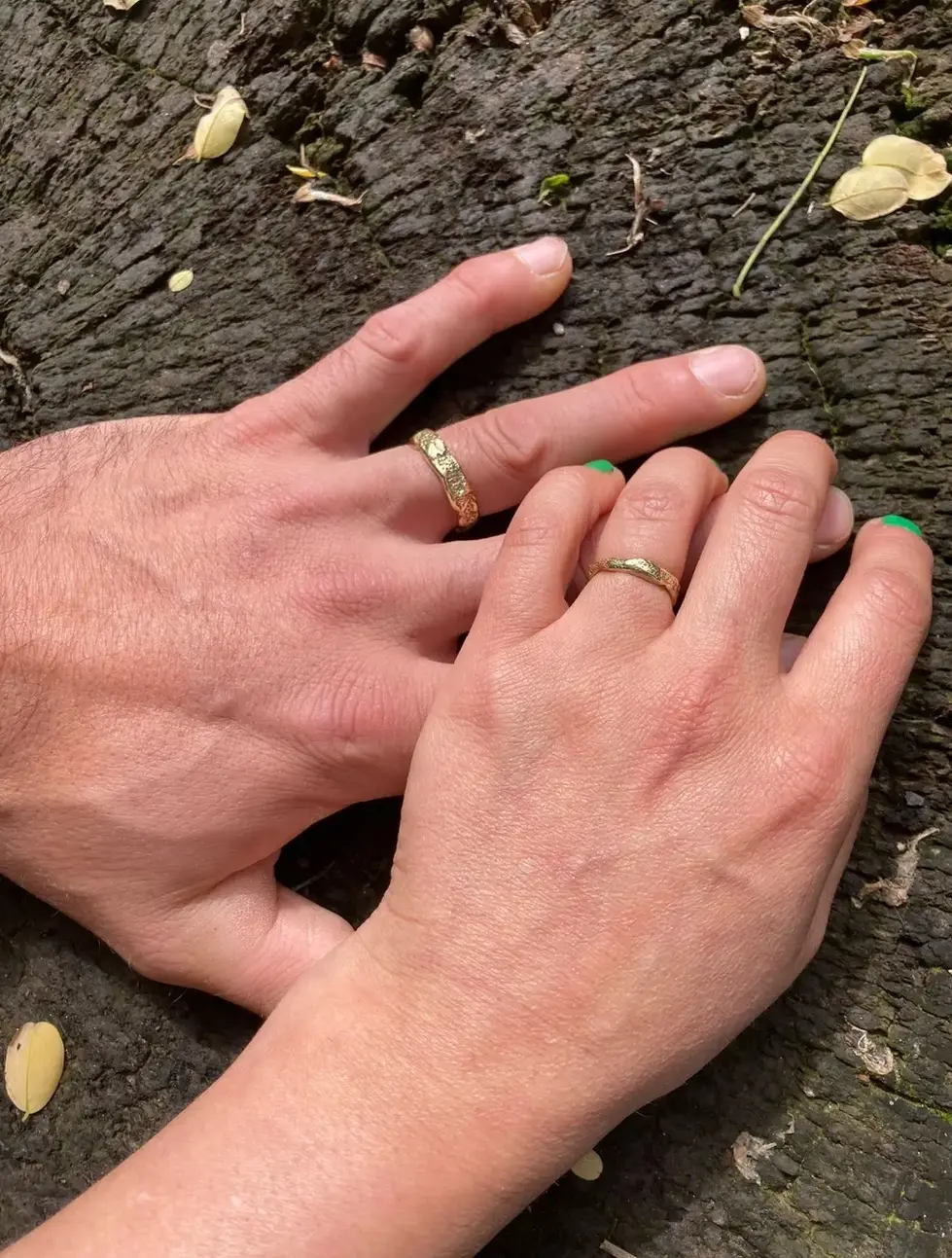 a man and a woman wearing wedding rings on their fingers