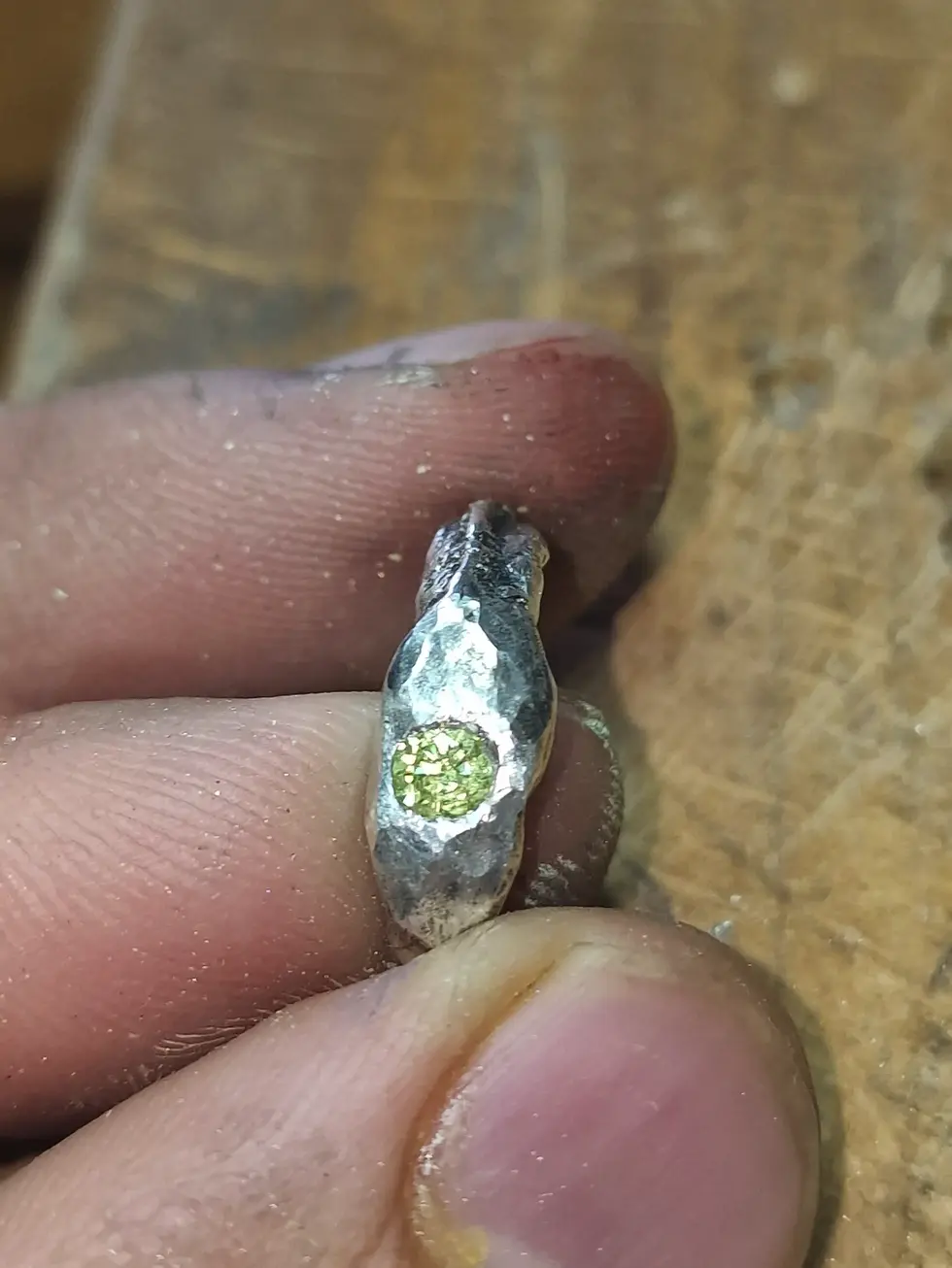 a silver ring with a green stone in the center