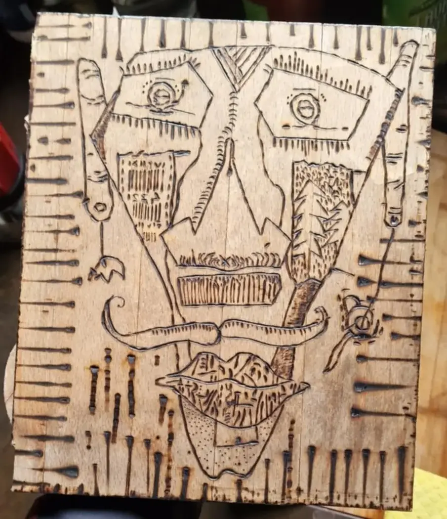 a drawing of a man 's face on wood