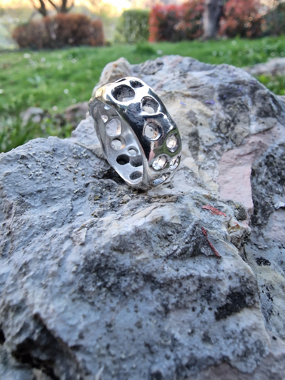 a silver ring is sitting on top of a rock