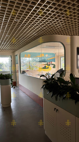 Modern interior space featuring sleek, curved glass walls and a sophisticated ceiling design.