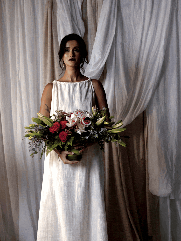 GIF of lady holding flowers in front of beige and white draping