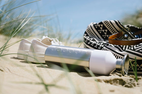 Metal dopper water bottle on the beach