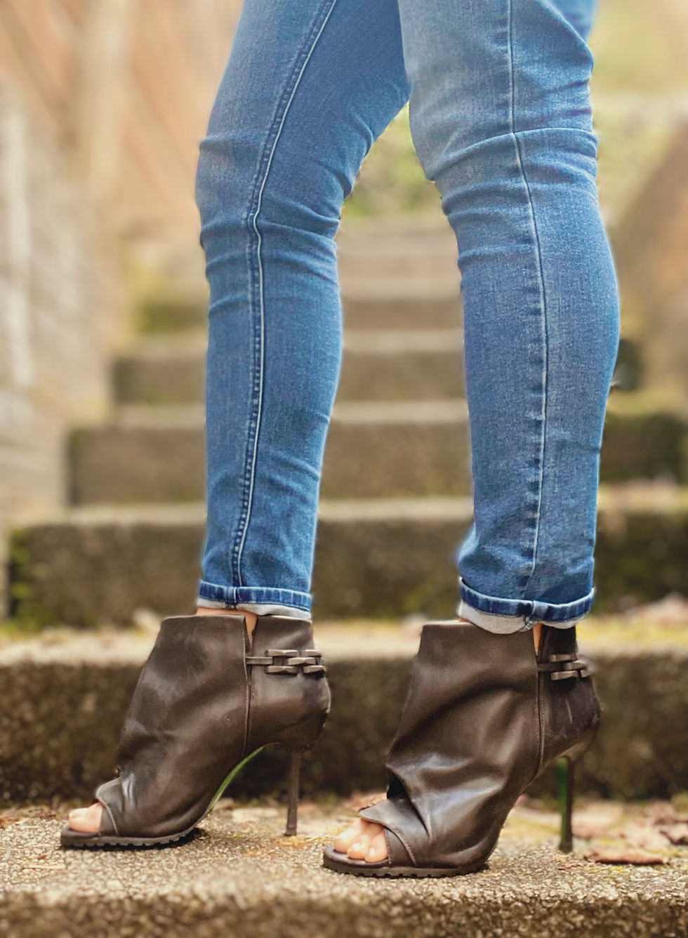 Black leather open toe stiletto booties paired with skinny jeans