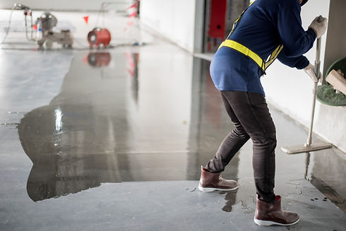 Construction worker painting epoxy flooring or floor hardener.jpg