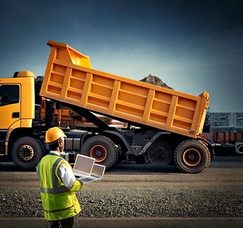 Firefly indian dumper truck and a man with laptop in hand looking at truck with industrial