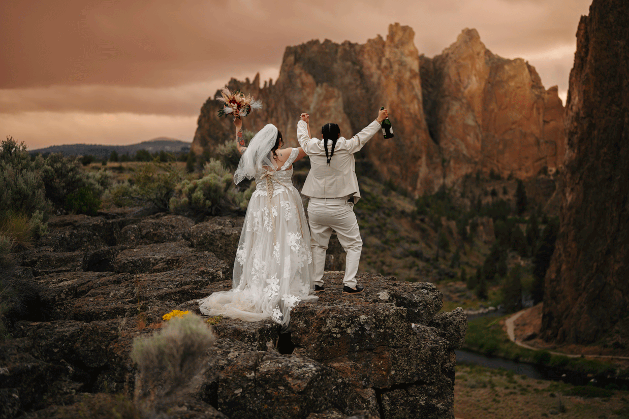 lesbian couple celebrating on clif at smith rock state park in oregon