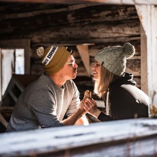 winter couple illuminated in sunlight in abandoned cabin