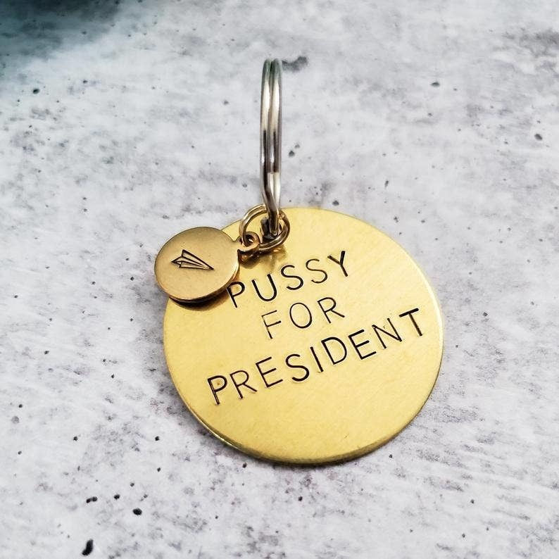 PUSSY FOR PRESIDENT Brass Key Chain with paper plane accent
