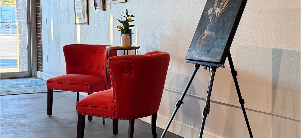 Red chairs and an easel in the gallery