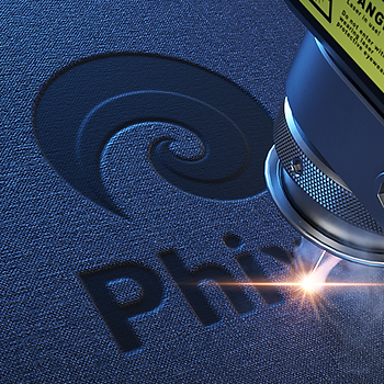 Laser engraving a logo on a dark sheet of material.