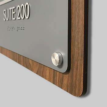 Metallic standoff on a wall mounted suite sign.