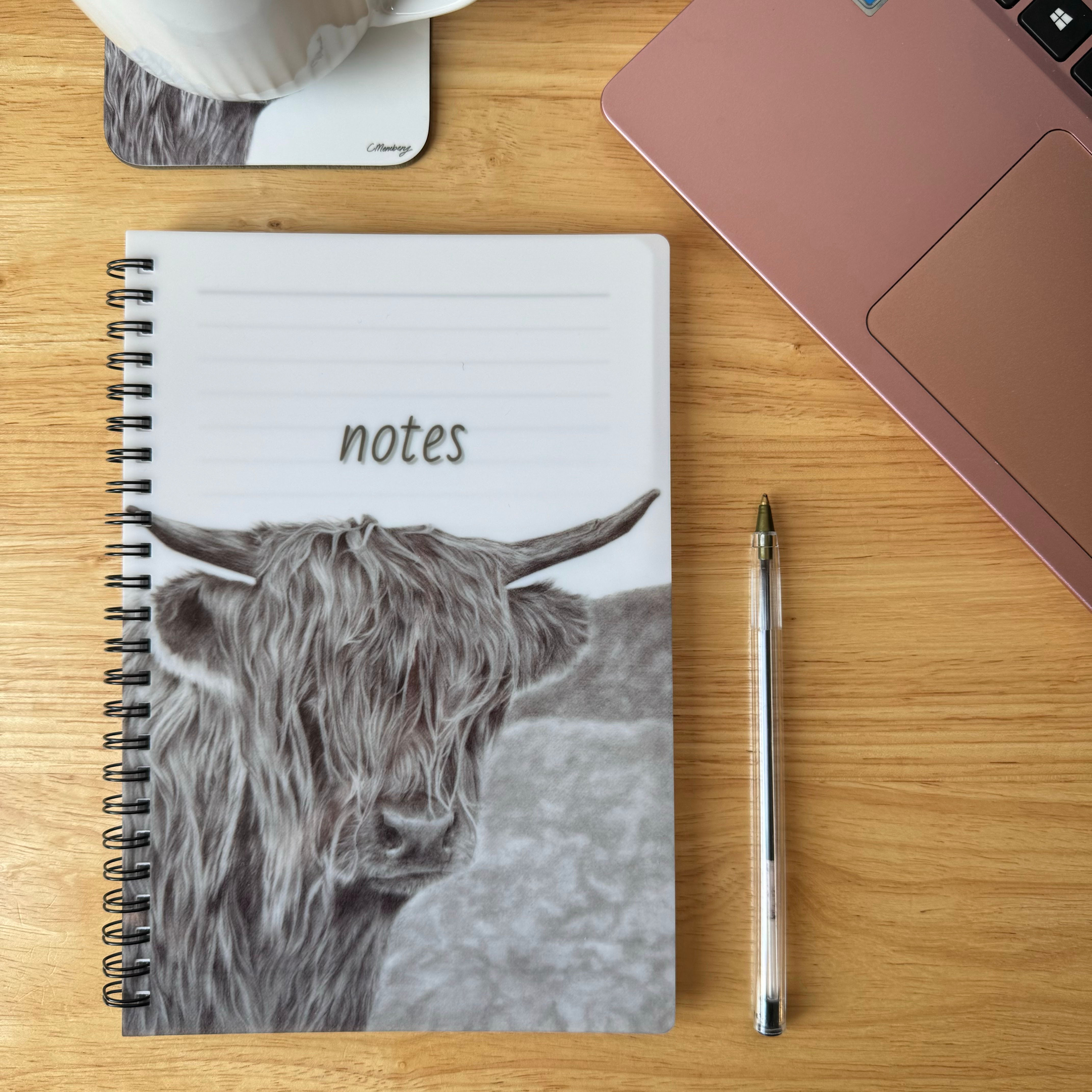 A5 notebook featuring hand drawn realistic graphite pencil artwork by Catrin Membery, highland cow with background