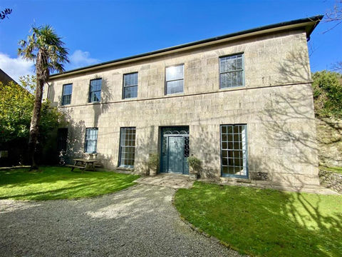 Leslie House, Helston. A grade II listed building built in 1810, featuring sash windows and a grand front door.