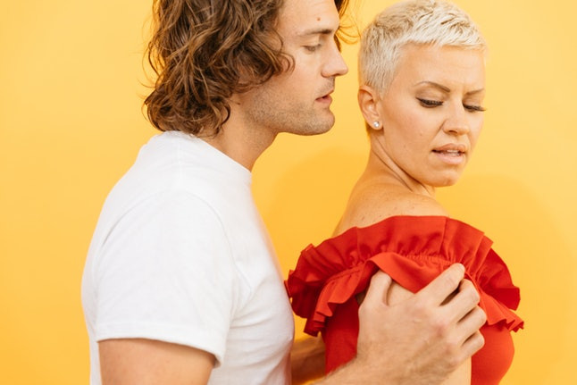 man holding woman with scowl face