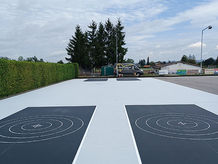 Frisch beschichtete Stockbahn im Freien mit blauen und weißen Kreisen – langlebige Sanierung für Vereine und Gemeinden