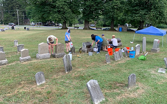 5 volunteers cleaning old gravestones