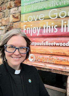 Phot of Pastor Rose Shepley in front of colorful banner