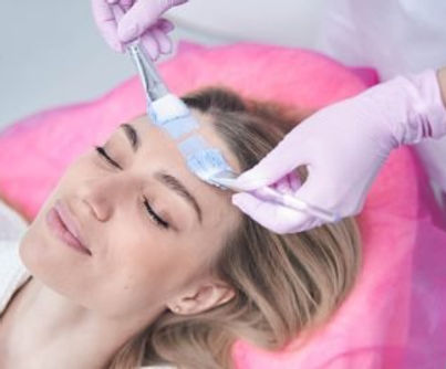 Cosmetologist applying mask on female client skin.jpg