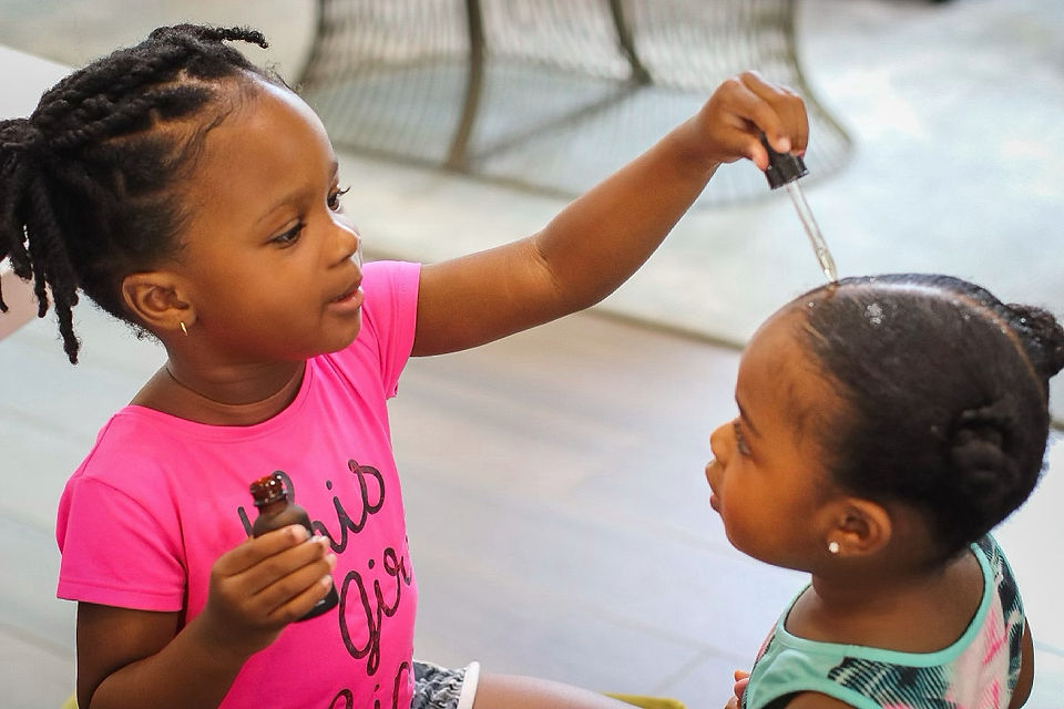 Person applying marula oil to hair to promote scalp health and showcase marula oil benefits.