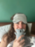 woman in bed with eye mask and a koala toy