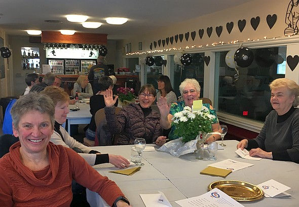 Group of people sitting down in a venue, smiling.