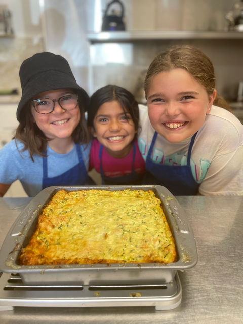 Happy campers showing food they helped prepare.