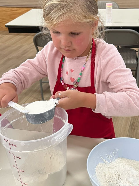 Young chef measuring ingredients.