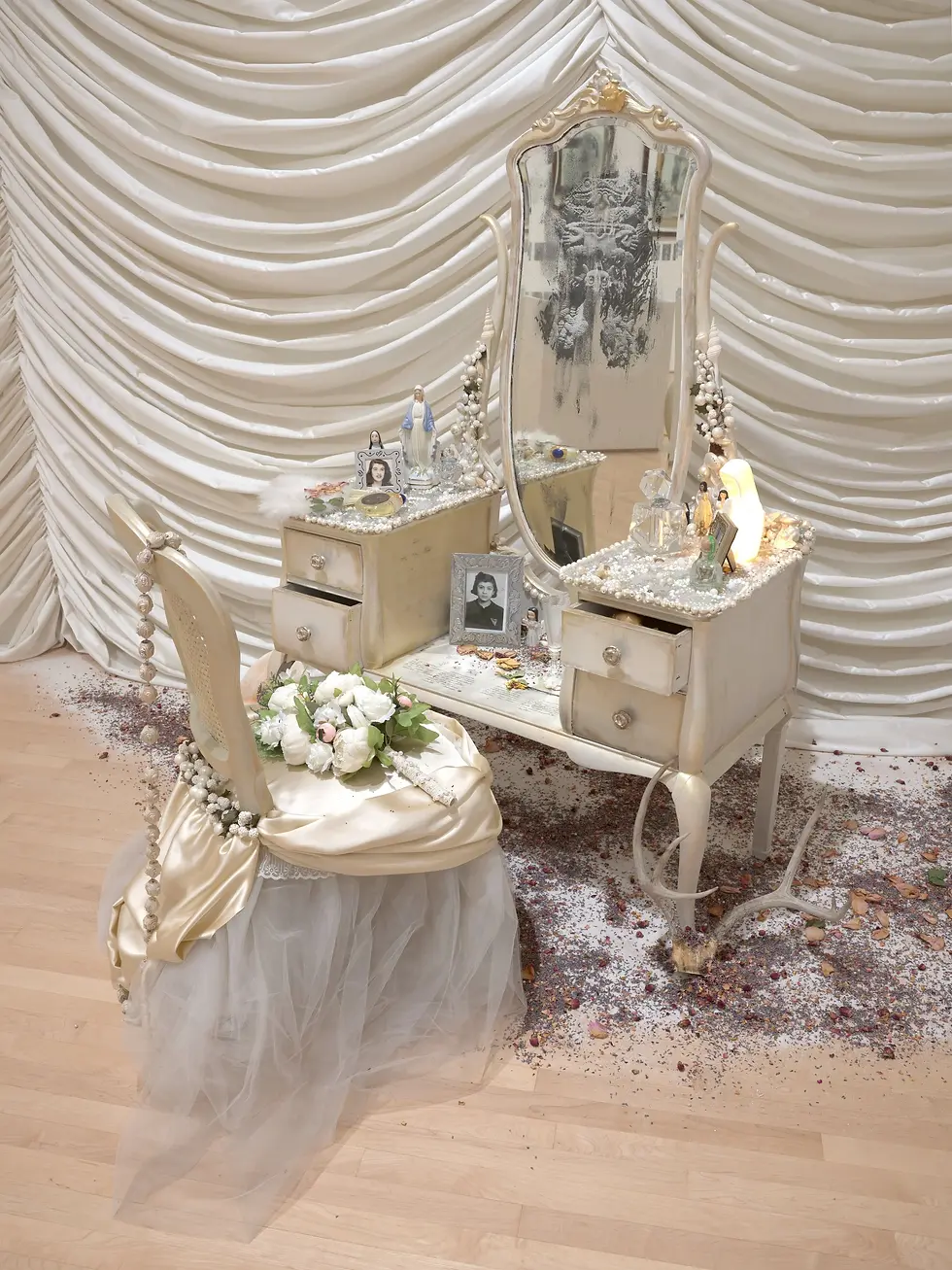 Mirror detail in Amalia Mesa-Bains installation art layered with images of women and history