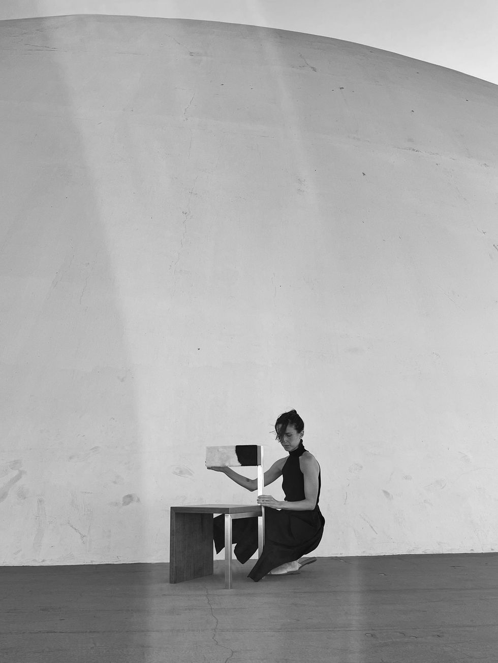 H04 Chair in an interior, showing its asymmetrical three-leg design.