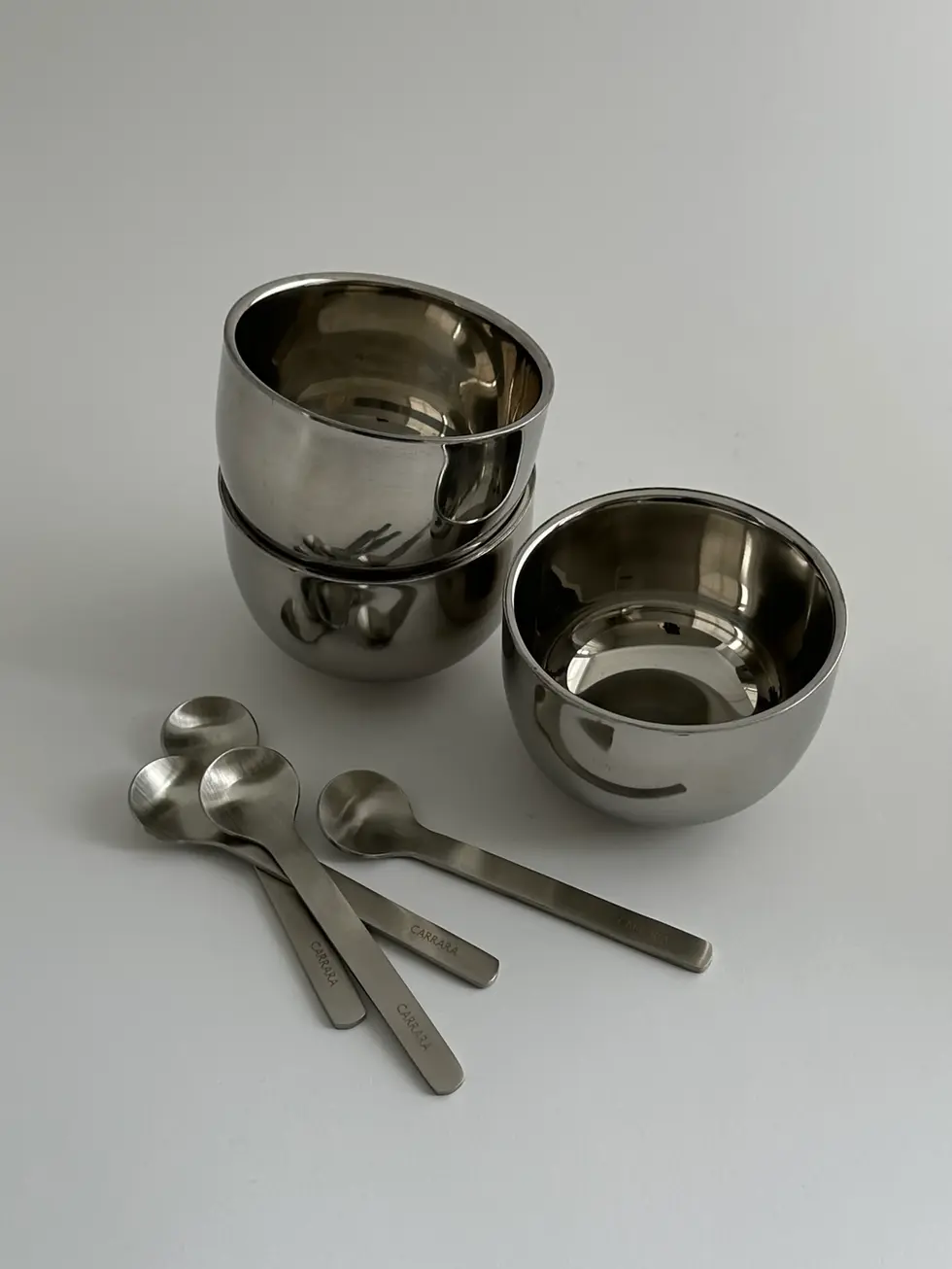 Minimalist stainless steel cups used for serving ice cream and small desserts with spoons